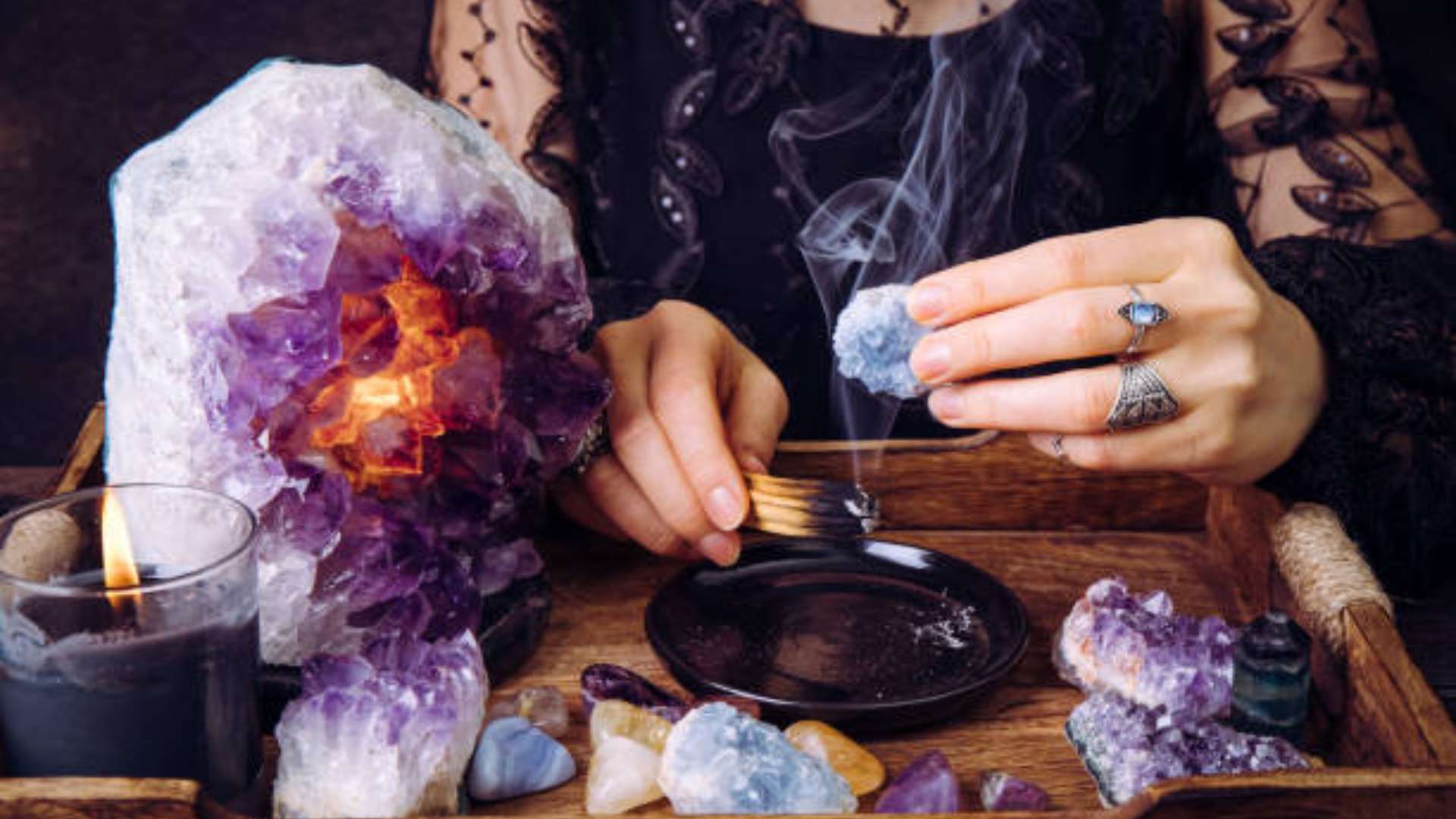 Person practicing crystal gazing in a peaceful, candlelit meditation space